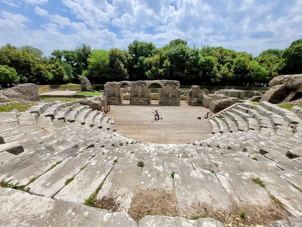 Historic ancient amphitheater surrounded by lush greenery in Albania.